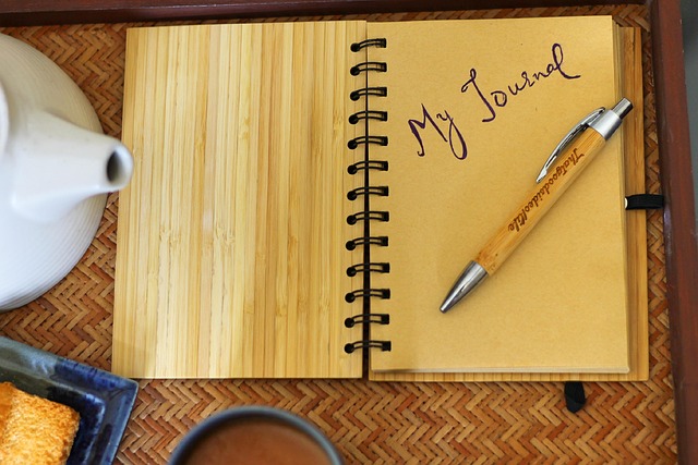 open journal notebook with pen on wooden workspace near window light
